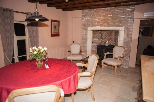 ein Esszimmer mit einem Tisch, Stühlen und einem Kamin in der Unterkunft B&B Castel 't Haantje in Ruiselede