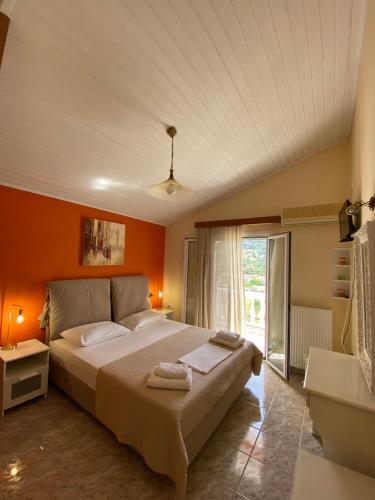 a bedroom with a large bed with orange walls at Myrtos Hotel in Divarata