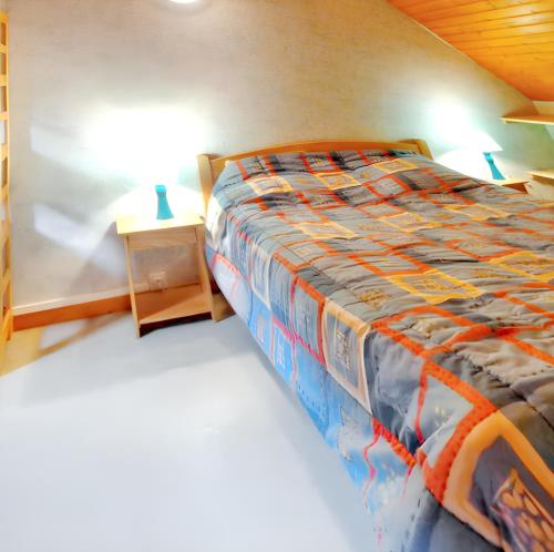 1 dormitorio con 1 cama con un edredón colorido en Maison de 3 chambres avec jardin clos a Aragnouet a 6 km des pistes, en Aragnouet