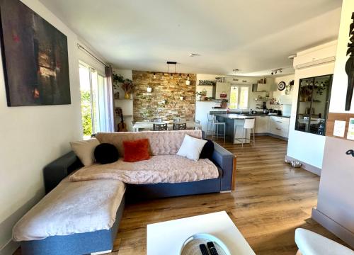 un salon avec un canapé et une cuisine dans l'établissement Jolie maison Borgo trois chambres trois salles de bain, à Borgo