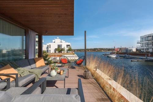 a patio with couches and a view of the water at Sol Marina Resort Wyspa Sobieszewska I - LoftAffair Collection in Wiślinka