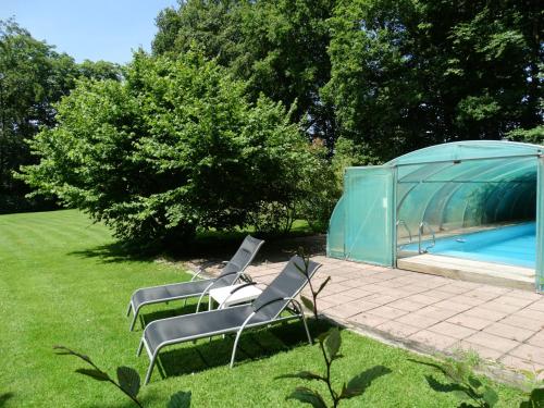 a group of chairs sitting next to a swimming pool at B&B Castel 't Haantje in Ruiselede