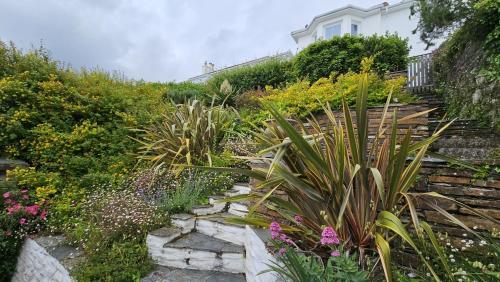 a garden with plants and flowers on a hill at The Summer House in Saint Mawes
