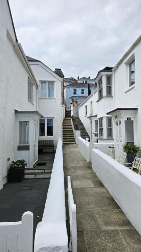 a row of white houses with stairs in the background at The Summer House in Saint Mawes