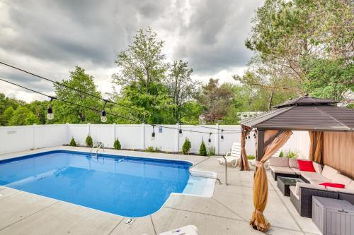 a swimming pool in a backyard with a white fence at Game Room and Fire Pit Poconos Family Getaway in Tobyhanna