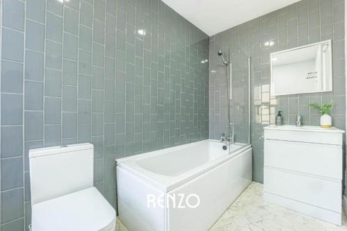 a bathroom with a tub and a toilet and a sink at Cosy and Lovely 3-bed Home in Lincoln by Renzo, Free Wi-Fi, Sleeps 8! in Lincolnshire