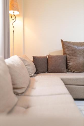 a living room with a couch with pillows and a lamp at Windmill 23 Apartment in Agios Nikolaos