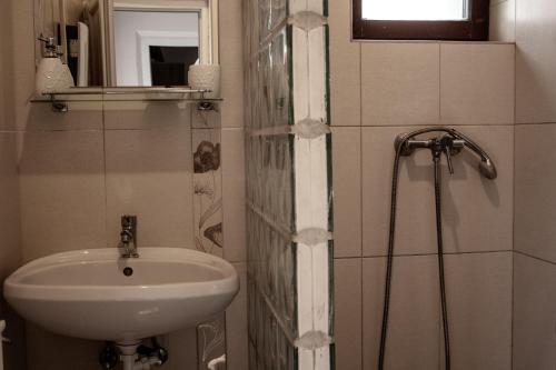 a small bathroom with a sink and a shower at Fitt Magánszálláshely in Sásd