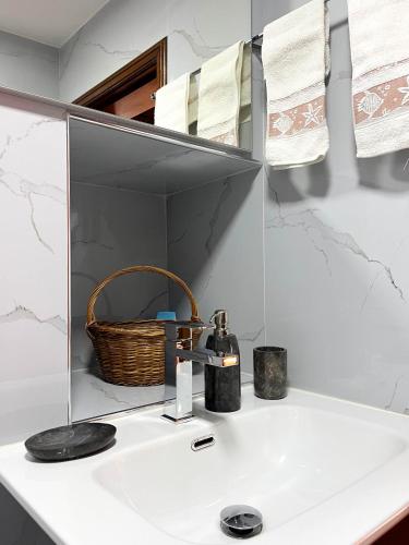 a bathroom sink with a basket and a mirror at Quinta do Tapadinho - Wine & Tourism in Moimenta