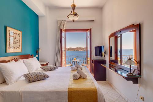 a bedroom with a bed with a view of the ocean at Electra Syros - Adults Only in Ermoupoli