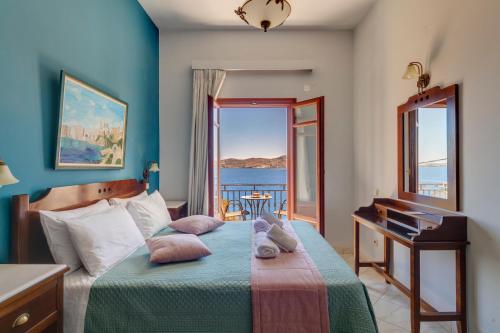 a bedroom with a bed with a view of the ocean at Electra Syros - Adults Only in Ermoupoli