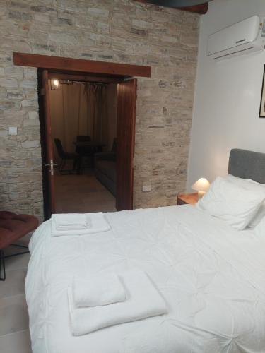 a bedroom with a white bed with two towels on it at AROMA DRYOS in Kato Drys