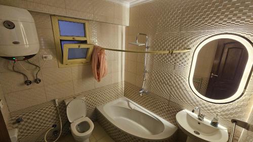 a bathroom with a sink and a toilet and a mirror at Alex sea view apartment - families only in Alexandria