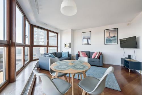 a living room with a table and chairs at Dom & House - Apartamenty Sea Towers in Gdynia
