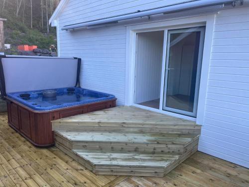 a hot tub sitting on a deck next to a building at Sea view Holmestrand sauna and hot tube appartment in Holmestrand