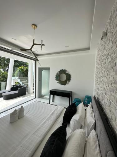a bedroom with a large bed and a brick wall at MIREVA Villas in Haad Pleayleam