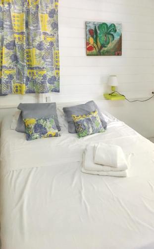 Una cama blanca con almohadas y una toalla. en Villa de 3 chambres avec vue sur la mer piscine privee et jardin clos a Le Carbet a 2 km de la plage en Le Carbet