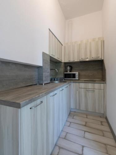 a kitchen with wooden cabinets and a counter top at Home Gramatikovi in Pomorie