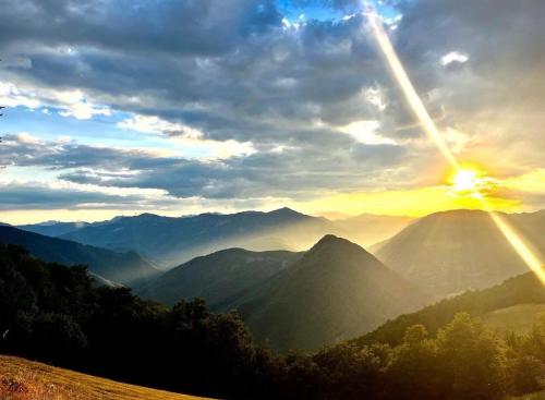 a sunset over a mountain range with the sun in the sky at Katun Lanista-Kolibe Bogavac in Mojkovac