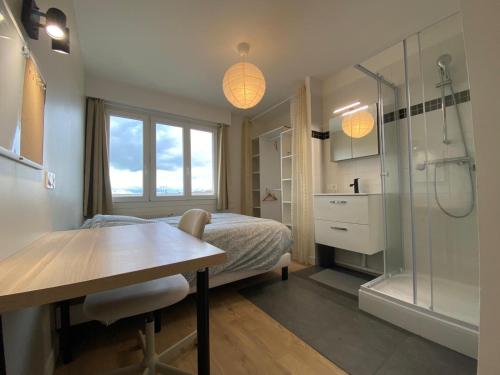 - une chambre avec un lit, une douche et une table dans l'établissement Grand appartement Standing reims centre Arena, à Reims