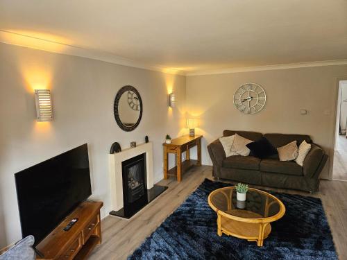 a living room with a couch and a fireplace at Redcot Gds Stamford 4 bed contractor,Disabled facilities home with Parking in Stamford