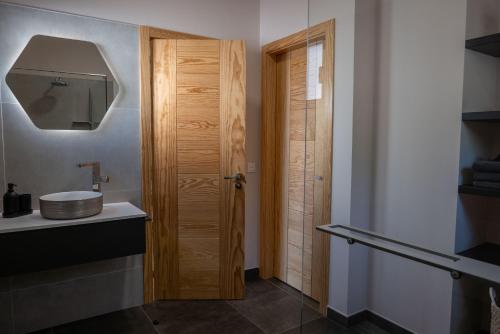 a bathroom with a sink and a wooden door at Finca Roberto by Don Robertos Finca Paraíso in Parque Holandes