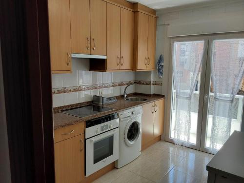 cocina con fogones y lavavajillas en Piso Gijon Centro, en Gijón