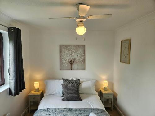 a bedroom with a bed with a ceiling fan at Redcot Gardens Stamford 4 bed contractor familt home with Parking in Stamford