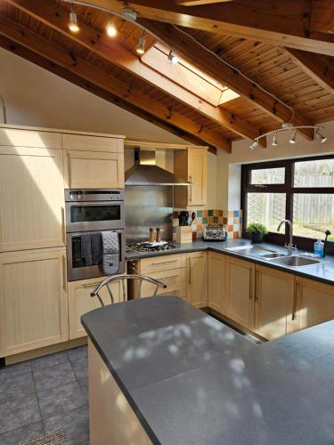 a kitchen with wooden cabinets and a stove top oven at Redcot Gds Stamford 4 bed contractor,Disabled facilities home with Parking in Stamford