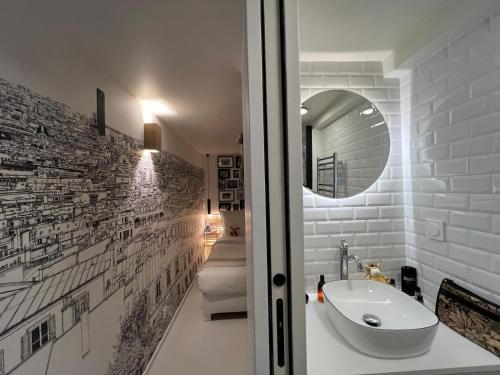 une salle de bain avec un lavabo et un miroir dans l'établissement Appartement Design Quartier Montmartre-Sacre-Cœur! Paris XVIIIe, à Paris