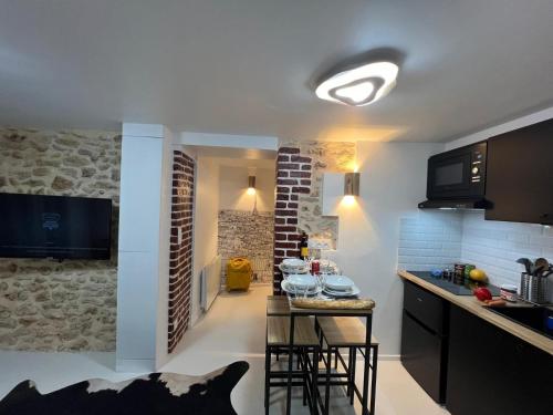 une cuisine avec une table avec des tabourets dans une pièce dans l'établissement Appartement Design Quartier Montmartre-Sacre-Cœur! Paris XVIIIe, à Paris