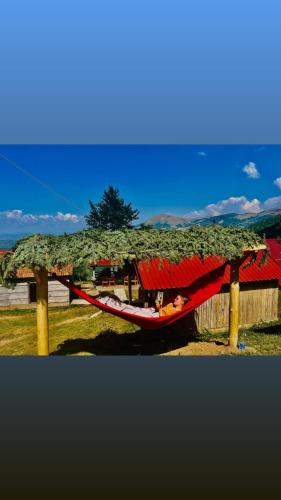 a person laying in a hammock under a roof at Katun Lanista-Kolibe Bogavac in Mojkovac