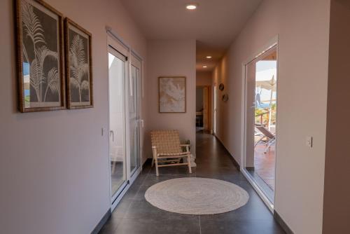 a hallway with a door and a chair and a rug at Finca Roberto by Don Robertos Finca Paraíso in Parque Holandes