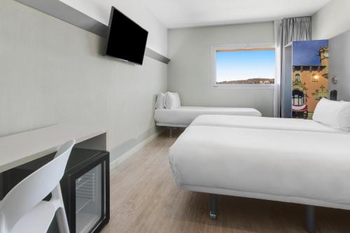 a hotel room with a bed and a tv at B&B HOTEL Barcelona Granollers in Les Franqueses del Vallès