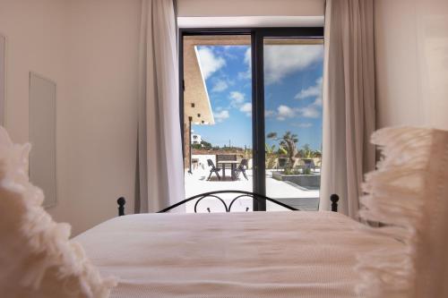 a bedroom with a bed and a view of a patio at Phaedrus Living Olive Grove Luxury Villa in Paphos