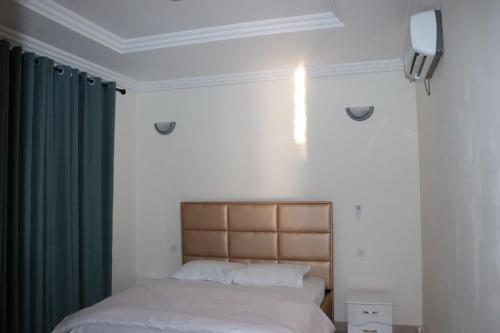 a bedroom with two beds and a green curtain at Résidence as salam in Yaoundé