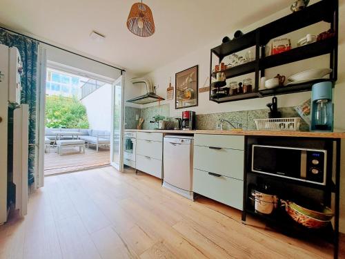 Eine Küche mit weißen Schränken und Holzboden in der Unterkunft LocBreuillet91 in Breuillet