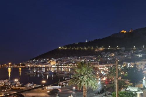 a city at night with boats in a harbor at ARGO Downtown Apartment in Kalymnos