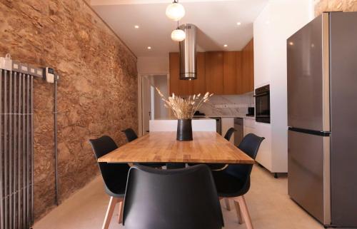 a dining room with a wooden table and black chairs at Phaedrus Living Olive Grove Luxury Villa in Paphos