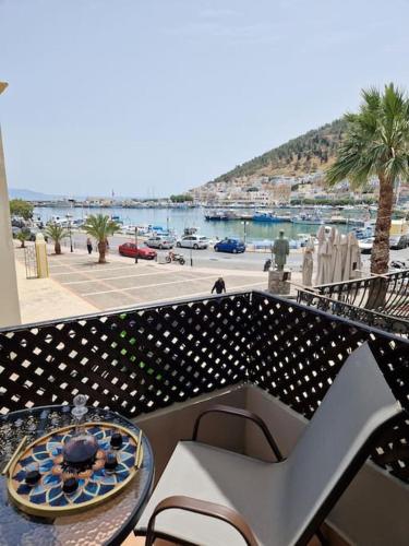 a balcony with a table and a view of a harbor at ARGO Downtown Apartment in Kalymnos