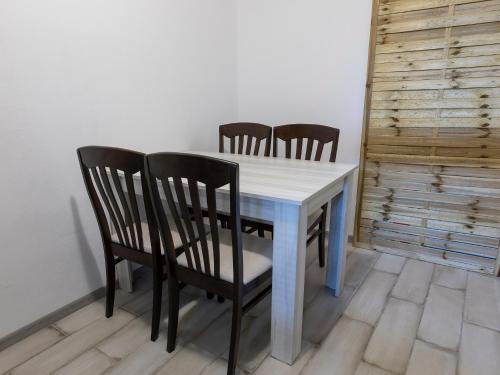 a dining room table with four chairs and a white table at Home Gramatikovi in Pomorie