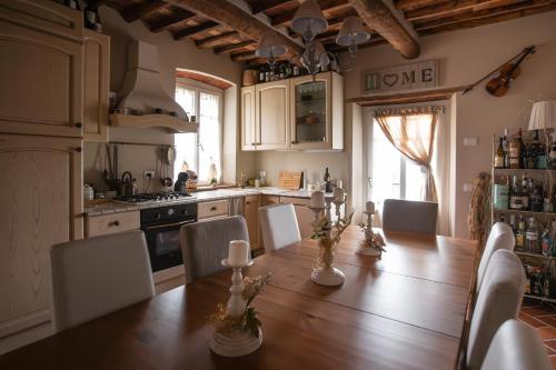 a kitchen with a long wooden table and chairs at Villa Lucetta, Emily, pool, fantastic view, Lucca in Matraia
