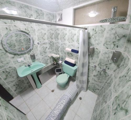 un bagno con doccia, WC e lavandino di Gold House Oro a Quito