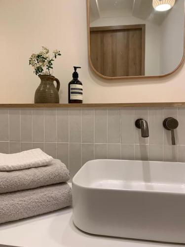 une salle de bain avec un lavabo blanc et un miroir dans l'établissement Maison Source, à Pornic