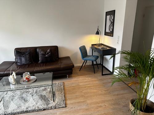 a living room with a leather couch and a desk at Interior Apartments in Kassel Bad Wilhelmshöhe in Kassel