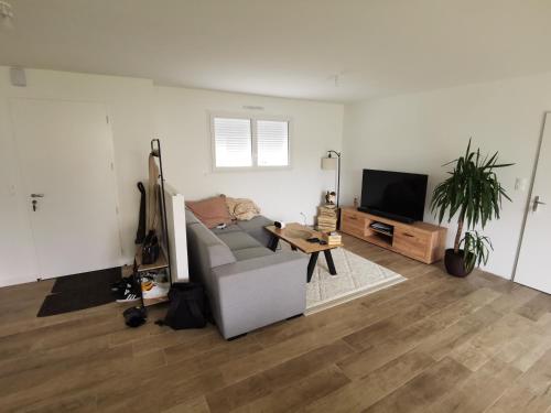 a living room with a couch and a flat screen tv at Maison 5 places proche circuit 24 heures in Fillé