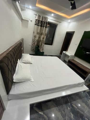 BharwainにあるHotel JAI MATA CHINTPURNI FAMILY HOTELの白いベッドバイザー付きの客室のベッド1台分です。