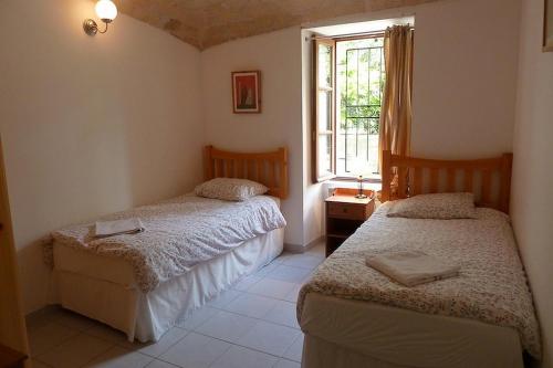 two beds in a room with a window at La Bastide des Lavandieres - Apartment Cerise in Canaules-et-Argentières