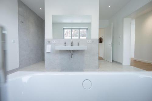 a white bathroom with a sink and a window at Dr. Bockemüller Appartements 