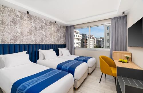 a hotel room with two beds and a window at Kenzi Solazur in Tangier